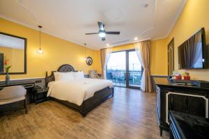 a hotel room with a bed and a television at Athenia Hoi An Boutique Hotel & Spa in Hoi An