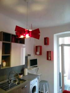 een keuken met een rode kroonluchter boven een wastafel bij Casa Vacanze Belli2 in Trieste