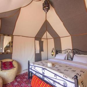 a bedroom with a bed in a tent at Berber Soul luxury Camp in Merzouga