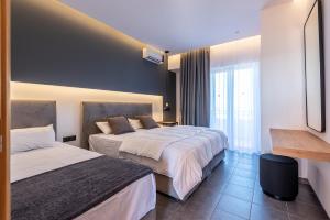 a hotel room with two beds and a window at Cirillo Family Hotel-Christinas Studios in Mastihari