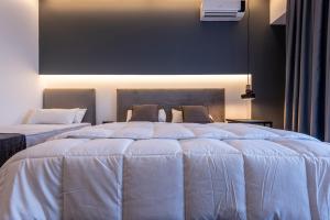 two beds with white comforters in a bedroom at Cirillo Family Hotel-Christinas Studios in Mastihari