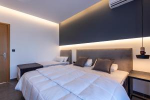 two beds in a bedroom with a large white bed at Cirillo Family Hotel-Christinas Studios in Mastihari