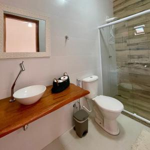 a bathroom with a sink and a toilet and a shower at Pousada Reserva de Itaúna in Saquarema