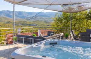 a hot tub on a balcony with a view of mountains at Villa Vito - with heated pool, whirlpool, gym in Šarići