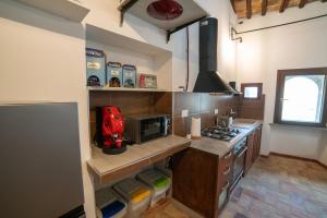 a kitchen with a stove and a microwave at La Residenza dei Priori in Tarquinia