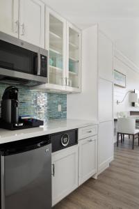 a kitchen with white cabinets and a stove top oven at The Capitana Key West in Key West