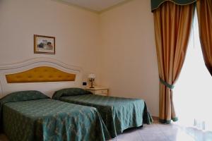 Posteľ alebo postele v izbe v ubytovaní Hotel Roscianum Welness SPA