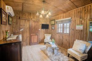 a living room with wooden walls and a chandelier at Hotel La Calma De Rita - Pirque in Pirque