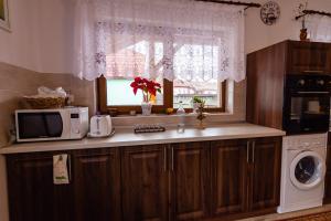 a kitchen with a microwave oven and a window at Csicsói Csűrház in Ciceu