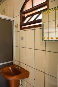 uma casa de banho com um WC em madeira e um espelho. em Casa da Mineira Hospedaria em Lençóis