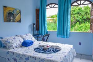 a bedroom with a bed with a teddy bear on it at Casa da Mineira Hospedaria in Lençóis