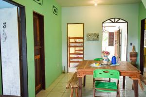 uma sala de jantar com uma mesa de madeira e paredes verdes em Casa da Mineira Hospedaria em Lençóis