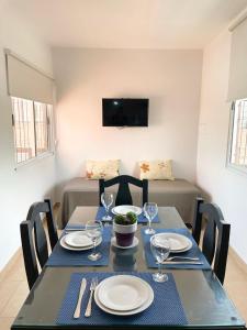 a dining room with a table with plates and wine glasses at complejo 25 de mayo in Guaymallen