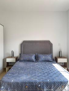 uma cama com um edredão azul e almofadas azuis em complejo 25 de mayo em Guaymallén