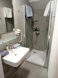 ein Bad mit einer Dusche, einem Waschbecken und einer Dusche in der Unterkunft Apartments Peter in Wien