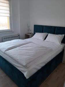 ein großes Bett mit blauem Kopfteil in einem Schlafzimmer in der Unterkunft Apartament na 9. piętrze in Oświęcim