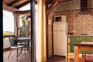 a kitchen with a refrigerator and a table on a balcony at Placer de Meca in Zahora