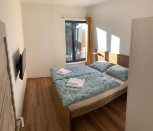 a bedroom with a bed with two towels on it at Apartmány na Plešivci in Abertamy