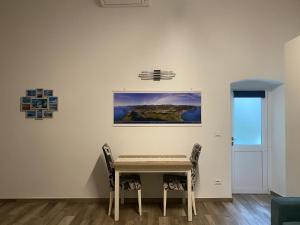 una mesa y sillas en una habitación con un cuadro en la pared en Monolocale Agata en Sestri Levante