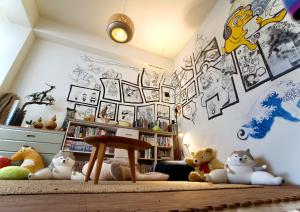 a room with stuffed animals and a wall with stickers at It's Mine Hostel in Taitung City