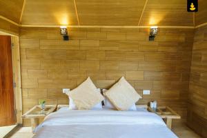 a bedroom with a large bed with wooden walls at LivingStone Shimla Jungle Stay in Shimla