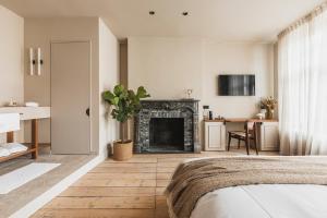 a living room with a fireplace and a bed at Raphaëlles Boutique b&b in Bruges