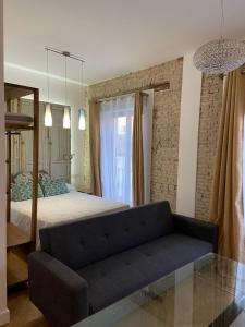um quarto com um sofá em frente a uma cama em CASA NAIA Santa Rufina 7 em Sevilha