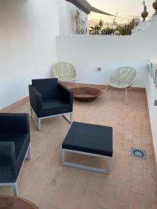 セビリアにあるCASA NAIA Santa Rufina 7の椅子2脚、テーブル、椅子が備わる客室です。