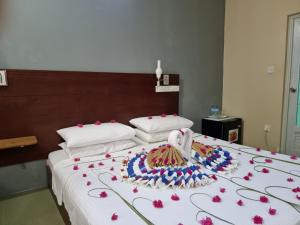 a bed with a bunch of flowers on it at Sunset Beach View in Dhangethi