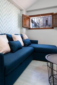 a blue couch in a living room with a table at Valentina Home in Málaga