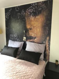 een slaapkamer met een bed met een muur van zwart en goud bij Chalet Bosrand 42 Park Veluwshof 6 p in Hoenderloo