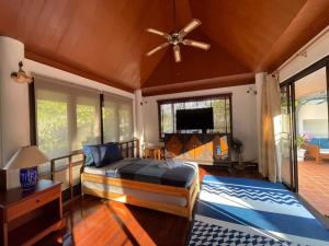 Schlafzimmer mit einem Bett und einem Deckenventilator in der Unterkunft Casa Khaoyai Bed&Breakfast in Mu Si