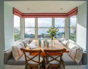 a living room with a table and a large window at Camel Point in Wadebridge
