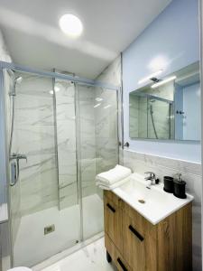 een badkamer met een douche, een wastafel en een spiegel bij CASA SOHO Y ALEX in Estepona