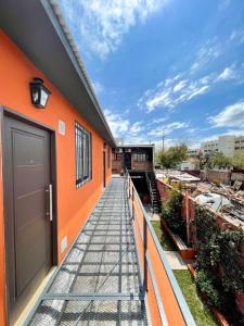 an orange building with a walkway next to it at complejo 25 de mayo in Guaymallen