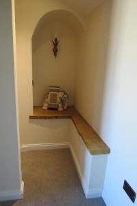 una habitación con un estante en la esquina de una habitación en Farthing Cottage en Bishop Auckland