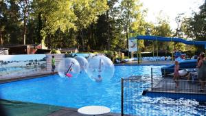 a swimming pool with a water park with people playing at Chalet Bosrand 42 Park Veluwshof 6 p in Hoenderloo