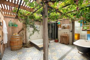 a bathroom with a tub and a sink and a barrel at Hotel La Calma De Rita - Pirque in Pirque +73 photos
