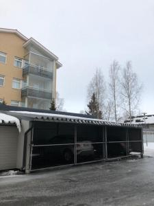 a garage with a car in it next to a building at Hannelen Varakoti in Loimaa