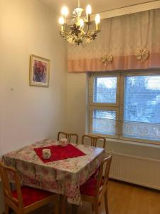 une salle à manger avec une table, des chaises et un lustre dans l'établissement Hannelen Varakoti, à Loimaa
