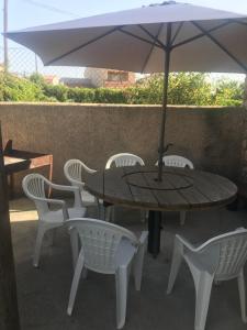 una mesa y sillas con una sombrilla en el patio en Casas Encinares, en Narrillos de San Leonardo