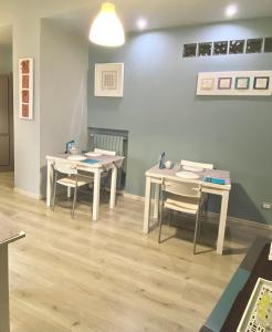 two tables and chairs in a room with wooden floors at Enna Inn Centro in Enna +28 photos