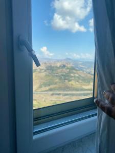 a person looking out of a window at a view at Enna Inn Centro in Enna