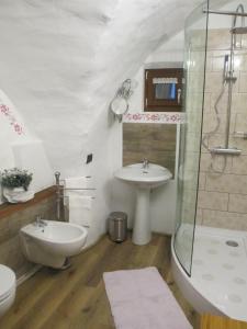 ein Bad mit einem Waschbecken, einem WC und einer Dusche in der Unterkunft PANEERIPOSO in Pergine Valsugana