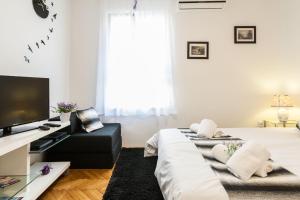 a bedroom with two beds and a flat screen tv at Bagi apartment in old town center in Zadar
