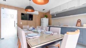 a dining room with a table and chairs at Flat Encantador Bauten Cabo Branco in João Pessoa