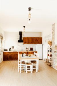 a kitchen with a white table and a white refrigerator at CASA RURAL LA VEGUILLA in Fuente del Arco