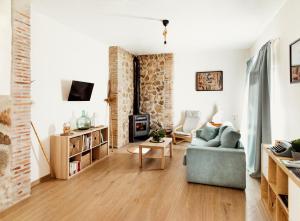 sala de estar con sofá azul y chimenea en CASA RURAL LA VEGUILLA, en Fuente del Arco