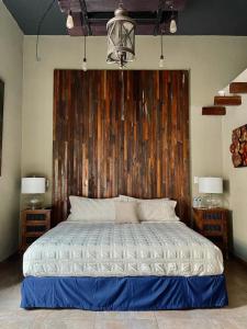 1 dormitorio con 1 cama grande y pared de madera en Independencia Dos 7 Hotel Boutique en Querétaro