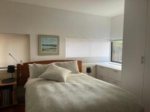 a bedroom with a large bed and a window at Beachside Taroona with Spa in Sandy Bay